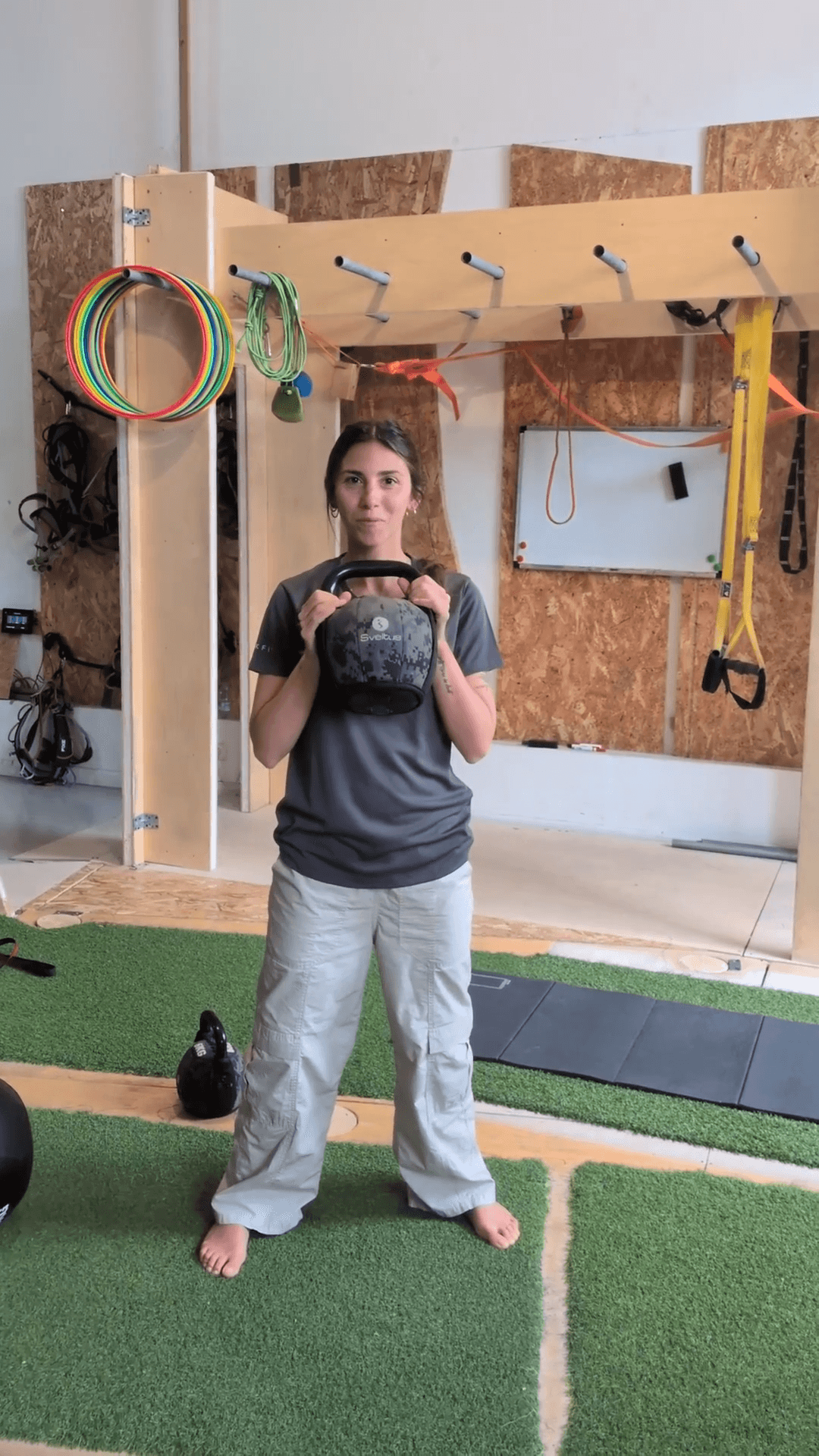 Magalí sosteniendo una kettlebell en una posición de fuerza consciente